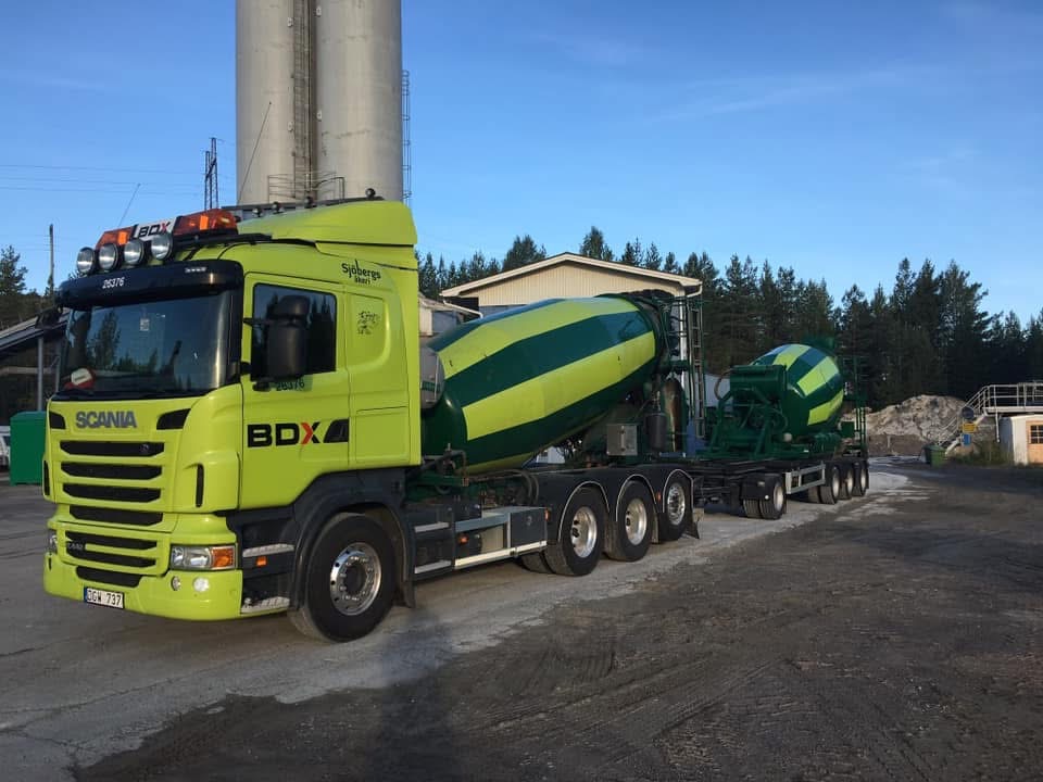 Betongbil med släpmixer vid betongstationen
