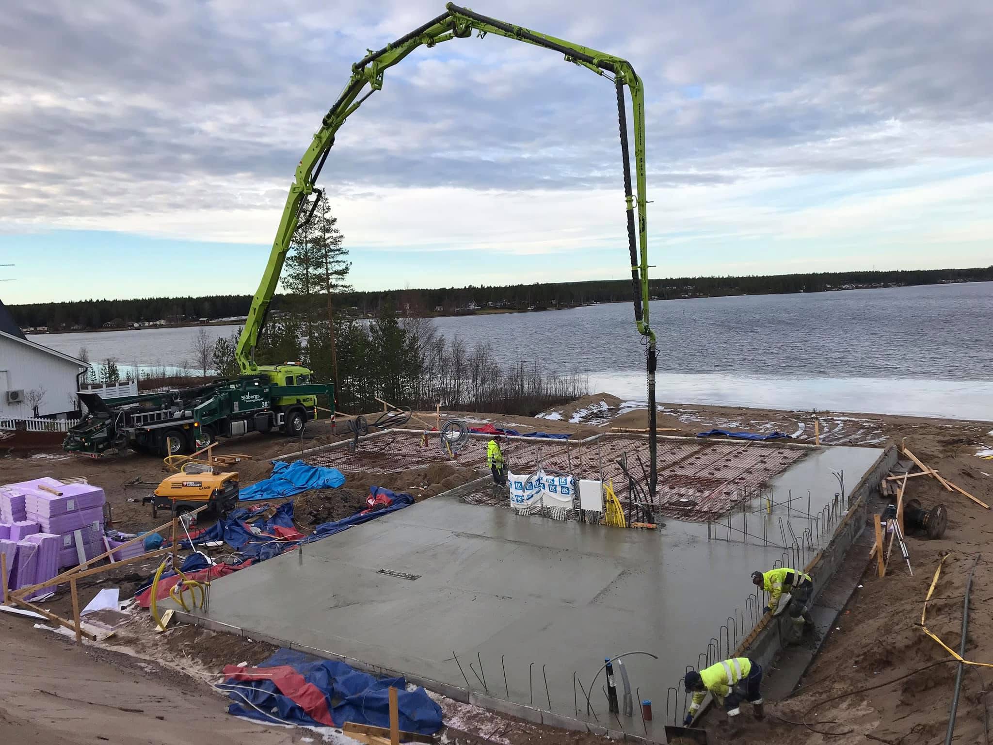 Betongpump från Sjöbergs Betongpumpar gjuter en husgrund vid vattnet